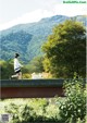 A woman walking a dog across a bridge.