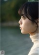 A woman in a white sweater looking away from the camera.