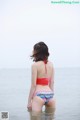 A woman in a bikini standing in the water.