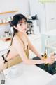 A woman sitting at a kitchen counter with a cup of coffee.