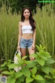 A woman standing in a field of tall grass.