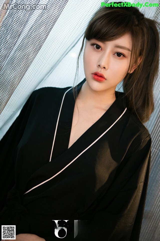 A woman in a black robe posing for a picture.