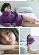 A woman in a purple sweater is laying on a bed.