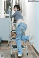 a woman standing on top of a ladder in a kitchen